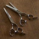 Hair cutting scissors and FIT thinning scissors with FIT Mizutani scissors canada brand logo on a wood table