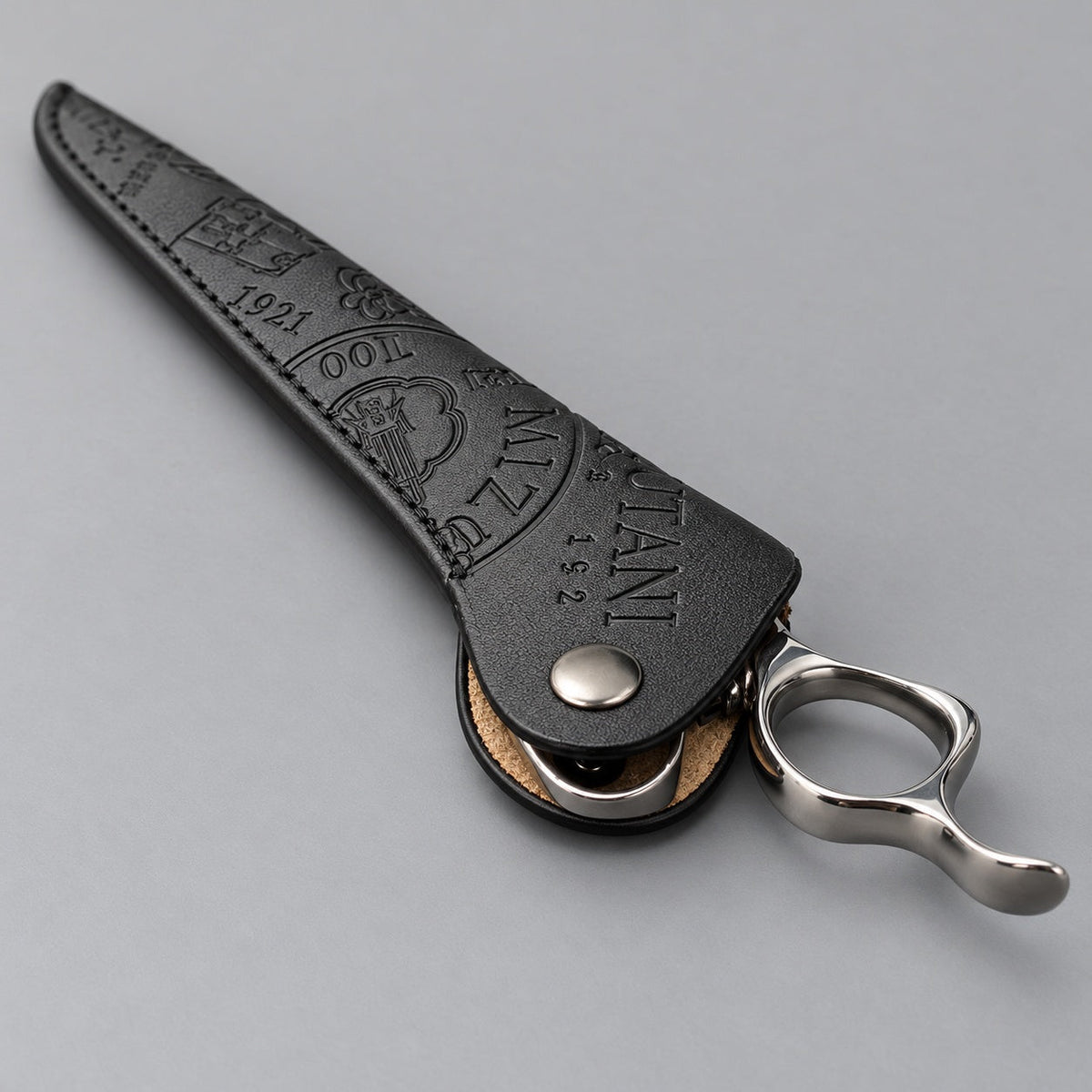 Mizutani Heritage Edition black embossed scissor sleeve holding scissors; scissors not included