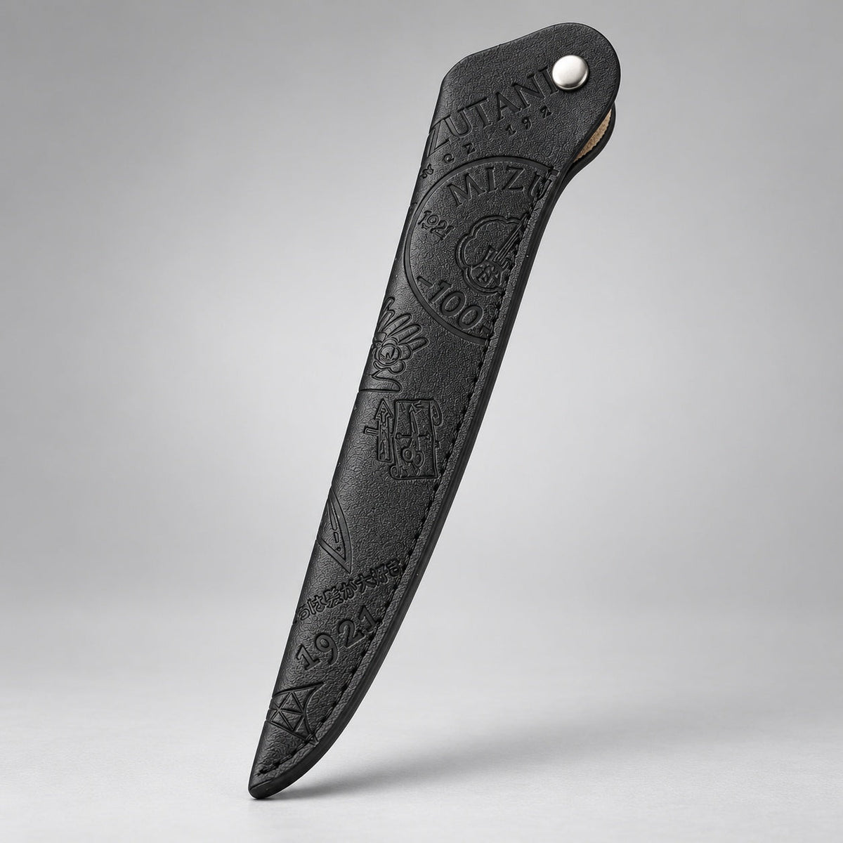 Mizutani Heritage Edition black embossed scissor sleeve, standing view showing tonal pattern and snap closure