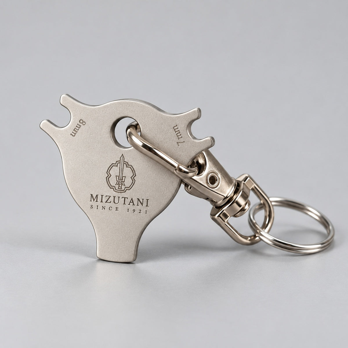 Mizutani scissors dial adjustment key with detachable swivel clasp and key ring, standing view